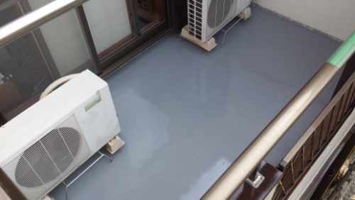 Balcony with a glossy gray floor and two outdoor air conditioning units along the wall.