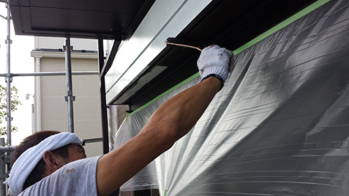 koushin_12hafu3 | 外壁塗装は神奈川県横浜市の塗装職人 Worker with white headband painting a building exterior, protected by plastic sheeting.
