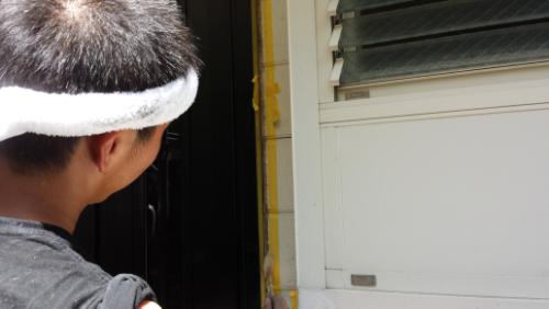 Person seen from behind wearing a white headband, facing a doorway next to a windowed wall.