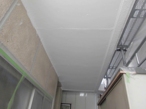 CIMG1380 | 外壁塗装は神奈川県横浜市の塗装職人 Indoor construction space with white drywall ceiling panels in place; exposed framework and scaffolding along the right side, with green tape protecting surfaces.